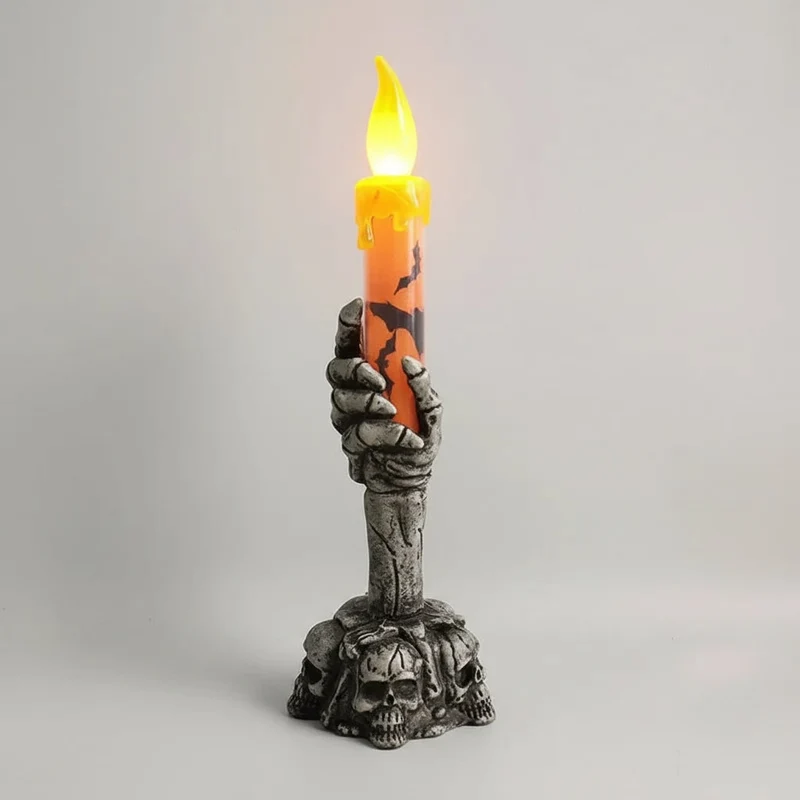 Decorative Halloween LED candle in a skeleton's hand with bats and skulls